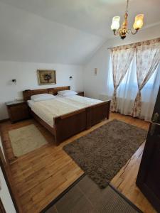 锡盖图马尔马切伊Pensiunea Iris的一间卧室配有一张大床和一个吊灯。