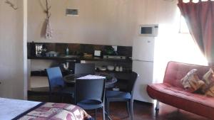 Molen Drift非洲之日旅馆的一间带桌子和沙发的客厅以及一间厨房。