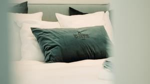 埃纲尔赫姆B&B De Tiendeschuur的床上的黑色枕头和白色枕头