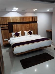 巴特那Hotel Crown Palace的一间卧室配有一张大床和木制床头板