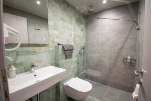 尼亚伊拉克利亚Heraclea Luxury Suites的浴室配有卫生间、盥洗盆和淋浴。