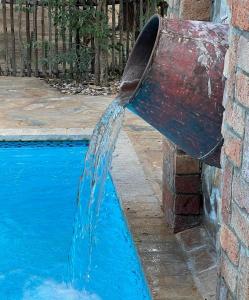 OpuwoKaoko Mopane Lodge & Campsite的喷泉倒入游泳池