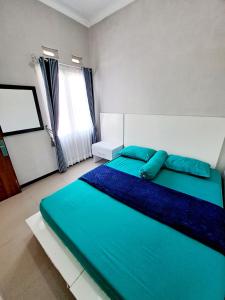 巴图Villa petit Tour的一间卧室配有一张带蓝色床单的床和一扇窗户。
