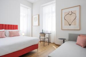 洛迦诺Villa Rossella的一间卧室配有两张床和一张桌子及椅子