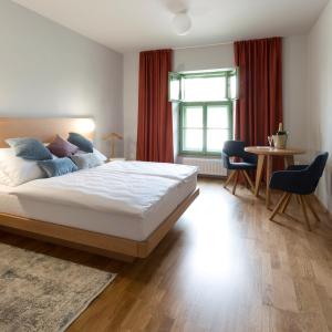 伊赫拉瓦Hotel Tři knížata的一间卧室配有一张床、一张桌子和一个窗户。