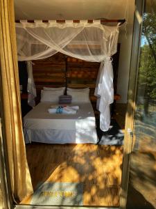 OpuwoKaoko Mopane Lodge & Campsite的一间卧室配有一张带天蓬的床