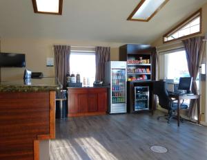 安大略Rodeway Inn & Suites的客房设有带冰箱和书桌的厨房。