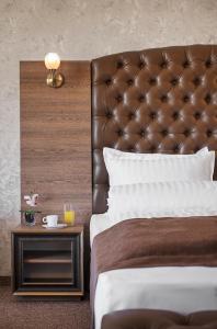 韦林格勒公园和Spa维拉山酒店的一张带皮革床头板和边桌的床