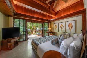 奥南海滩Centara Grand Beach Resort & Villas Krabi的一间卧室配有一张床和一台平面电视