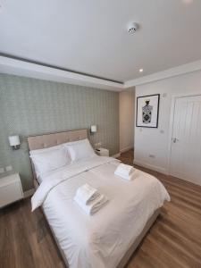伦敦Hotel CG London的卧室配有一张白色大床和两条毛巾