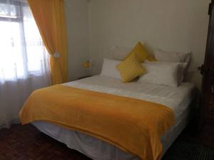 谢普斯敦港The Holiday Home on the Beach的一间卧室配有一张带黄色和白色枕头的大床