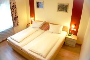 格斯韦因斯泰因苏木洛文宾馆的一间卧室配有一张带白色床单的大床