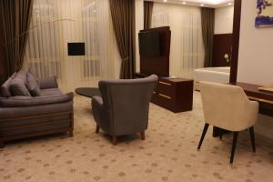 吉布提Golden Airport Hotel的酒店客房,配有沙发、椅子和一张床