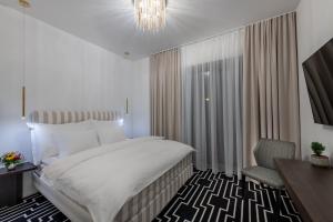 米哈洛夫采Hotel ZEMPLEN的一间卧室配有一张床、一把椅子和一个吊灯。