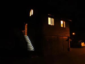 克里克豪厄尔The Studio, Upper House Farm, Crickhowell.的夜间的房子,楼梯通往门