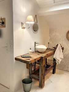 色当VILLA NOTRE DAME face au Château fort的木桌上带水槽的浴室