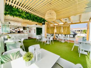 奇皮奥纳鲁兹码头公寓酒店的一间设有白色桌椅的餐厅,种植了植物