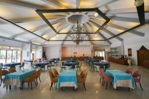 帕莫卡莱Halıcı Hotel Resort & SPA的一间配备有蓝色桌椅和吊灯的餐厅