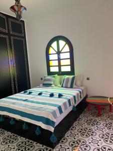 索维拉Riad Aïcha Addi - Poolside - Traditional Moroccan的一间卧室设有一张大床和窗户
