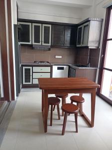 帕讷杜勒Villa Suyara的厨房配有木桌和凳子