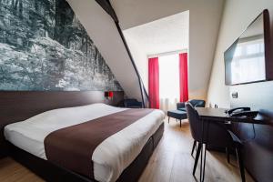 阿珀尔多伦阿珀尔多伦海特鲁堡垒酒店的酒店客房设有一张大床和一张书桌。