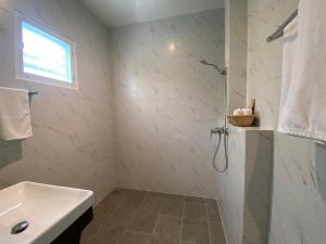 卡农勒派提特圣特罗佩度假屋的白色的浴室设有水槽和淋浴。