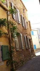 里耶Charming home in Provence - 6 pers.的街道上带有绿门的砖砌建筑