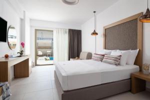 尼基季Imagine Luxury Suites的一间带一张白色大床的卧室和一个阳台