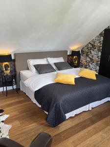 海斯特奥普登贝尔赫Rooftop terrace suite的一间卧室配有一张带黄色枕头的大床