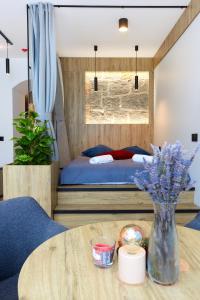 卡尔帕奇Apartament "Powoli" z darmowym parkingiem的一间卧室配有一张床和一张鲜花桌