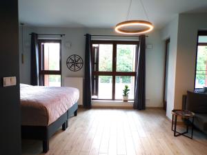 波兹南Bookowska Dal Cuore Apartment的一间卧室设有一张床和两个大窗户