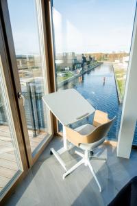SvencelėLAUNAGIS Apartments - Svencelės Vėjai的窗户客房内的白色桌子和椅子