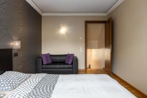 里加Jekabpils 2 Apartment的一间卧室配有一张床和一张皮沙发