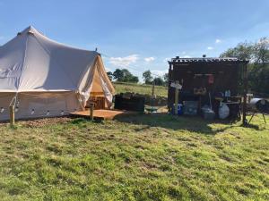利克Roaches Retreat Eco Glampsite - Wallaby Way Bell Tent的一个大帐篷和田野中的棚子