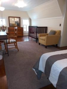 Brick House Retreat的卧室配有1张床、1张桌子和1把椅子