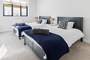StokeinteignheadStunning Coastal Apartment in Maidencombe with Sea Views & Garden的蓝色和白色的客房内的两张床