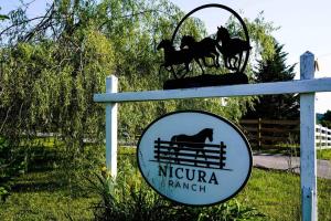 伯里亚Nicura Ranch Inn & Stables的 ⁇ 上马匹的尼尔瓦那牧场标志