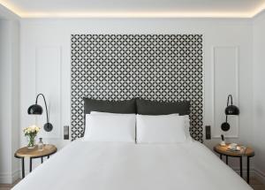 巴塞罗那Serras Barcelona的卧室配有一张白色的大床和两张桌子