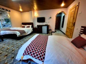 KārandūkaiBlue Water Resort Kalam的酒店客房设有两张床和电视。
