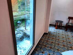 KārandūkaiBlue Water Resort Kalam的一间设有玻璃门和瓷砖地板的客房