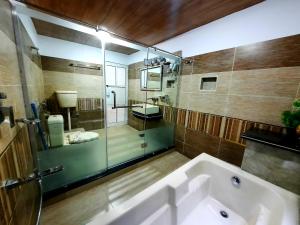 KārandūkaiBlue Water Resort Kalam的带浴缸、淋浴和盥洗盆的浴室
