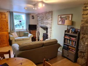 NantlleNorth Wales Cosy Cottage with views near Eryri Snowdonia的带沙发和石制壁炉的客厅