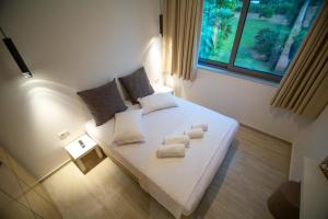 普雷韦扎Elea resort的卧室配有白色床和毛巾