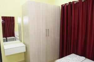 海得拉巴SWEET HOMES的一间卧室配有木制橱柜和红色窗帘