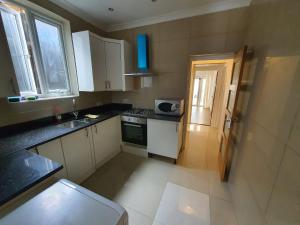 伦敦Private Room- Direct Travel Central/ Heathrow的小厨房配有白色橱柜和水槽