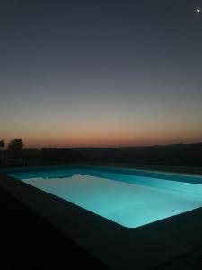 卡兰达Cabezo Buñuel Hostal的夜晚的蓝色泳池与天空