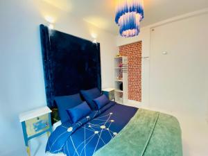 勒帕莱Appartement Vert du Palais - Relaxation Centrale的一间卧室配有蓝色的床和2个吊灯