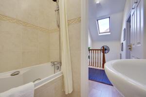 伯恩茅斯Talbot Woods Villa的带浴缸和盥洗盆的浴室