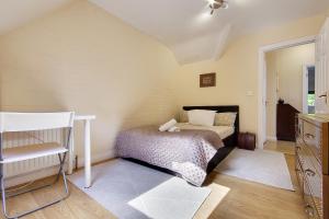 伯恩茅斯Talbot Woods Villa的一间卧室配有一张床和一把椅子