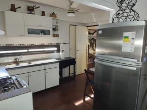 罗萨里奥La Nenena的厨房配有白色橱柜和不锈钢冰箱